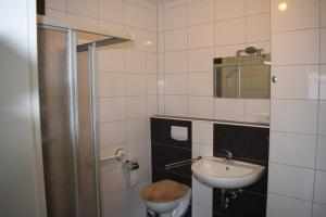 La salle de bains est pourvue d'un lavabo, de toilettes et d'un miroir. dans l'établissement Apartment in 48599 Gronau Monteurzimmer 2, à Gronau
