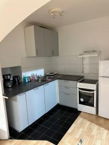 a kitchen with white cabinets and a sink and a stove at Ferienwohnung Kreuzberg in Berlin