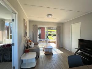 un soggiorno con divano e tavolo di Gulf Red Vacation Home 2 Bedroom 2 Bathroom a Whangaparaoa