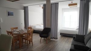 a living room with a dining table and a bedroom at Aparthotel Passage in Giżycko