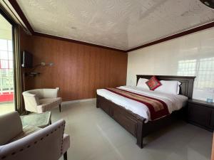 穆里的住宿－Shagufta Hotel & Restaurant Murree，一间卧室配有一张大床和一把椅子