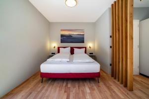 a bedroom with a white bed with red pillows at Villa Rosa Unterschöberlehof - Lene in Merano