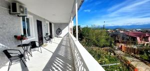 a balcony with chairs and tables on a house at HillTop Guest House Kutaisi in Kutaisi +13 photos