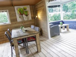 a wooden deck with a wooden table and chairs at Cozy tentlodge with roofed terrace in a green area in IJhorst