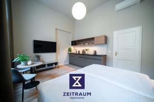 a bedroom with a bed and a table and a tv at Karl BY ZEITRAUM in Prague