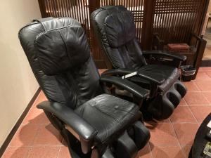 two black leather chairs sitting next to each other at グッドホテル大阪 in Toyonaka