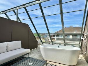 eine Badewanne in einem Zimmer mit einem großen Fenster in der Unterkunft Rafael Kaiser - Premium Apartments City Centre - Contactless 24h Check-In in Wien