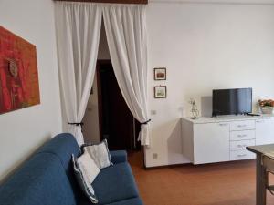 a living room with a blue couch and a tv at Appartamenti RO in Follonica