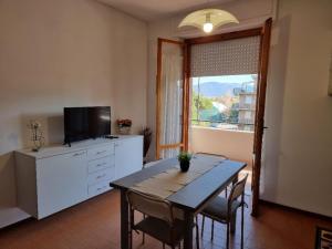 a living room with a dining room table and a window at Appartamenti RO in Follonica