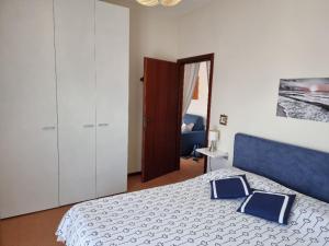 a bedroom with a bed with a blue and white blanket at Appartamenti RO in Follonica