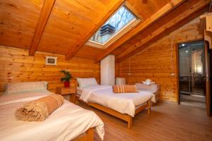 a bedroom with two beds in a log cabin at Bee Eco Guest House in Mollʼ e Shoshit