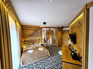 a hotel room with two beds and a television at Willa Regina I Resort & SPA in Zakopane