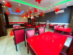 a dining room with red tables and red chairs at Hotel Orchid Saffron at Janakpuri in New Delhi