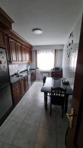 a large kitchen with a table and a window at Pirámides Ourense in Ourense