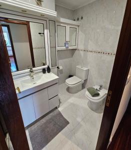 a bathroom with a sink and a toilet and a mirror at Pirámides Ourense in Ourense +4 photos