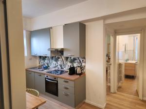 uma cozinha com armários brancos e um forno com placa de fogão em corso francia suite em Roma