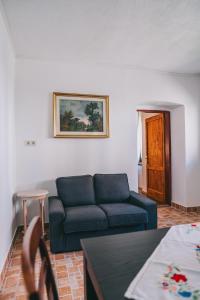 een woonkamer met een blauwe bank en een tafel bij Feher Barany Apartment in Szigliget