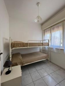 1 Schlafzimmer mit 2 Etagenbetten und einem Fenster in der Unterkunft Appartamenti NA in Follonica