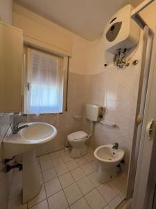 ein Bad mit einem Waschbecken und einem WC in der Unterkunft Appartamenti NA in Follonica