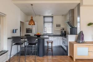 a kitchen with a island with bar stools at Luxe vakantiewoning dichtbij strand in Vlissingen in Vlissingen