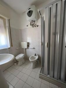 ein Badezimmer mit einem WC, einer Badewanne und einem Waschbecken in der Unterkunft Appartamenti NA in Follonica