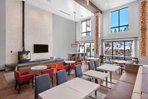 a restaurant with tables and chairs and a fireplace at Home2 Suites By Hilton Big Bear Lake in Big Bear Lake