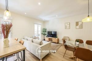 een woonkamer met een bank en een tafel bij MyHouseSpain - Renovado y luminoso apartamento in Madrid