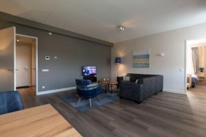 sala de estar con sofá y mesa en Design apartment in Zeeland with its own wellness, en Colijnsplaat