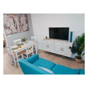 ein Wohnzimmer mit einem blauen Sofa und einem Tisch in der Unterkunft Pontevedra Apartments - Peregrina Family Suite in Pontevedra