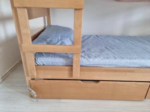 a small bed with a wooden frame with a drawer at Bgd Downtown Hostel in Belgrade