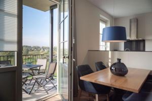 a dining room with a table and chairs and a balcony at Design apartment in Zeeland with its own wellness in Colijnsplaat