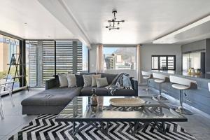 uma sala de estar com um sofá e uma mesa em Bella 703 - De Oude Schuur em Cidade do Cabo