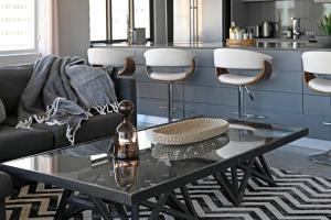 uma sala de estar com um sofá preto e uma mesa de vidro em Bella 703 - De Oude Schuur em Cidade do Cabo