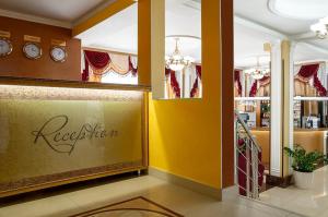 una tienda con paredes amarillas y relojes en la pared en Hotel Olymp Pervaya Liniya, en Adler