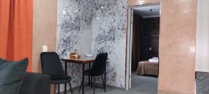 a room with a table and chairs and a bedroom at EVFRAT-Q in Taraz