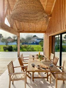 a wooden table and chairs on a patio at Belle Villa Terra Mare classée 4 étoiles entre océan et bassin in Lège-Cap-Ferret +84 photos