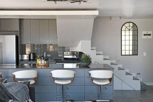 uma cozinha com um balcão com bancos e uma escadaria em Bella 703 - De Oude Schuur em Cidade do Cabo