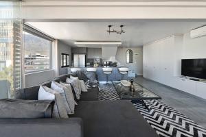 uma sala de estar com um sofá grande e uma cozinha em Bella 703 - De Oude Schuur em Cidade do Cabo