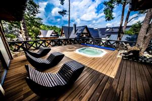 una terrazza con due sedie e una piccola piscina di Domki Osada Bacówka Radawa & SPA a Radawa