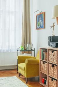 a living room with a yellow chair and a table at Historic Old Town Home in Budapest