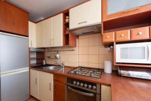 a small kitchen with wooden cabinets and a sink at Student District in the Heart of Łódź&Free Parking in Łódź