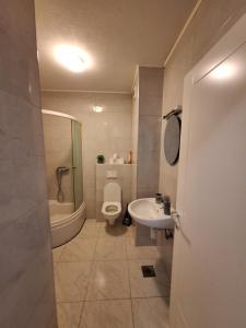 a bathroom with a toilet and a sink and a tub at Apartman Sarah - Autobuska Stanica in Tuzla