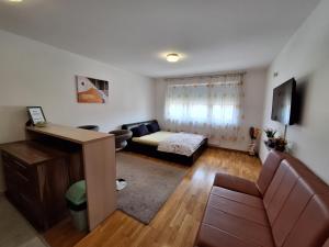 a small living room with a couch and a bed at Apartman Sarah - Autobuska Stanica in Tuzla