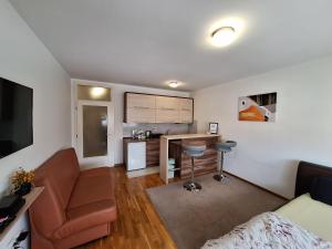 a small living room with a couch and a kitchen at Apartman Sarah - Autobuska Stanica in Tuzla