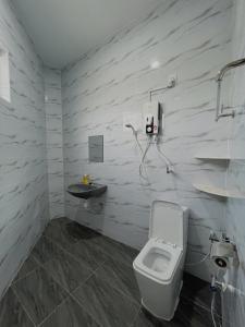 een badkamer met een toilet en een wastafel bij Elonna Homestay in Jerantut