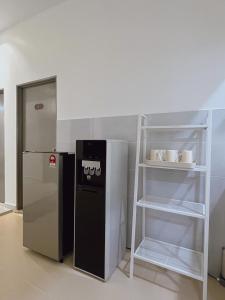 een keuken met een koelkast en een plank bij Elonna Homestay in Jerantut