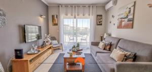 a living room with a couch and a tv at #093 Kid Friendly Ocean View with AC, Pool in Albufeira