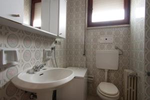 a bathroom with a sink and a toilet at Appartamento TL in Follonica +7 photos