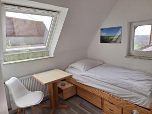 a small bedroom with a bed and a desk at Metzgerei und Pension Wolz in Langenburg
