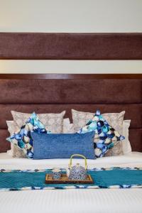 a bed with blue and white pillows and a purse on it at Sonam Plaza in Ludhiana